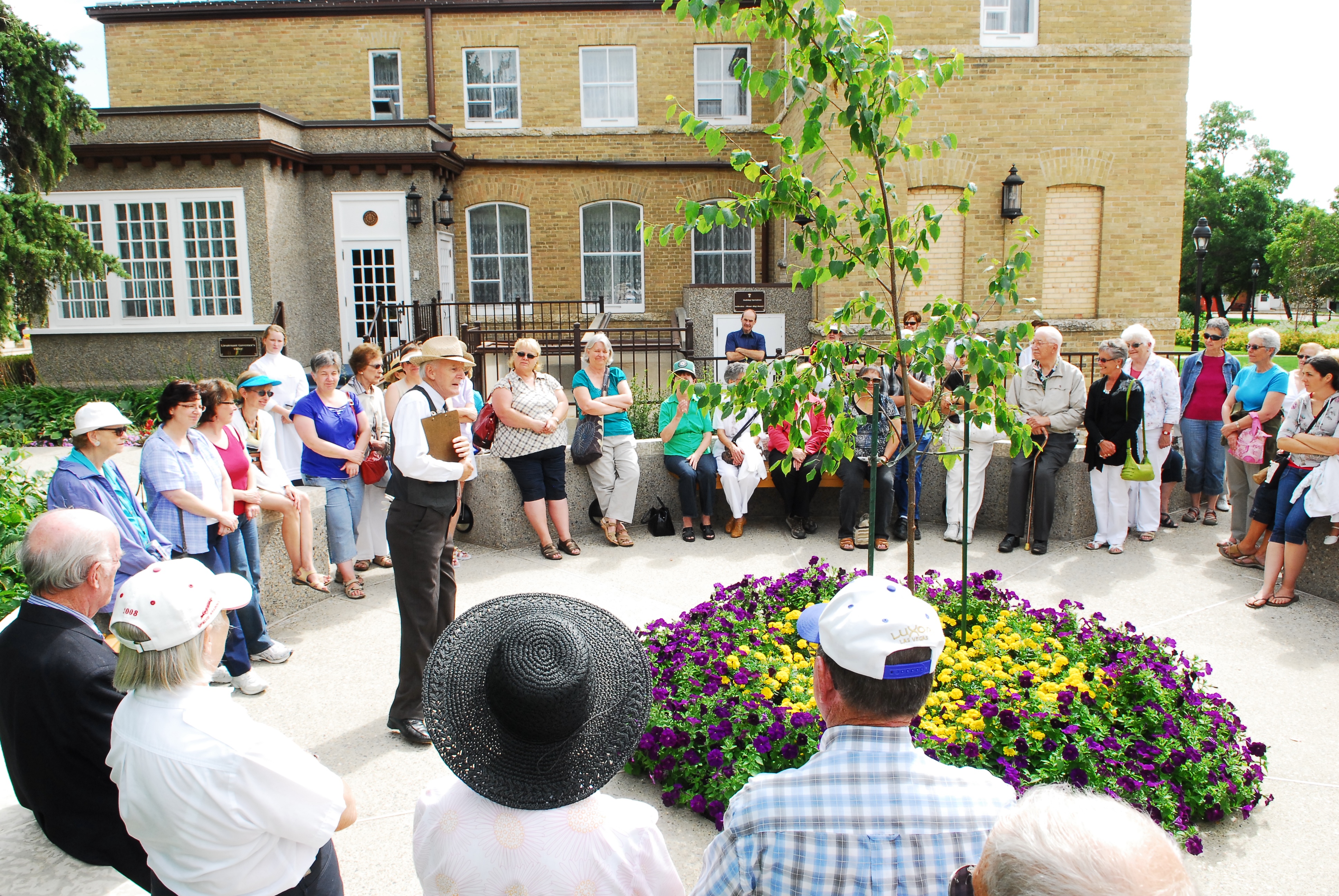 An actor dressed as the character George Watt giving a tour of the Government House SK gardens