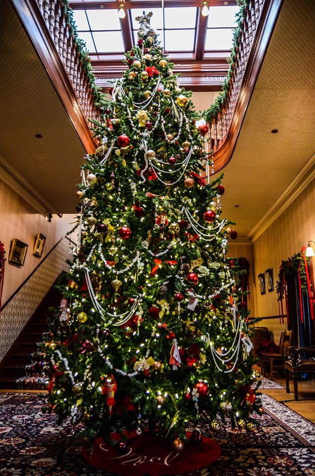 Tall fully decorated Christmas tree in the museum main hall at Government House Saskatchaewan.