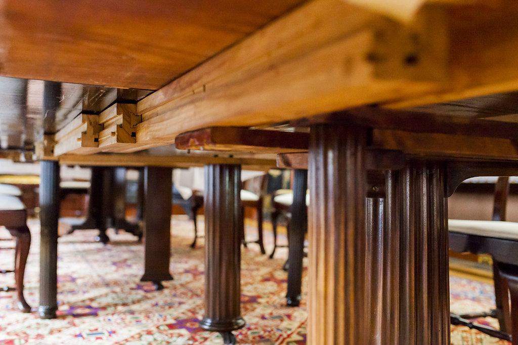 The underside of a wooden dining room table in the Government House museum