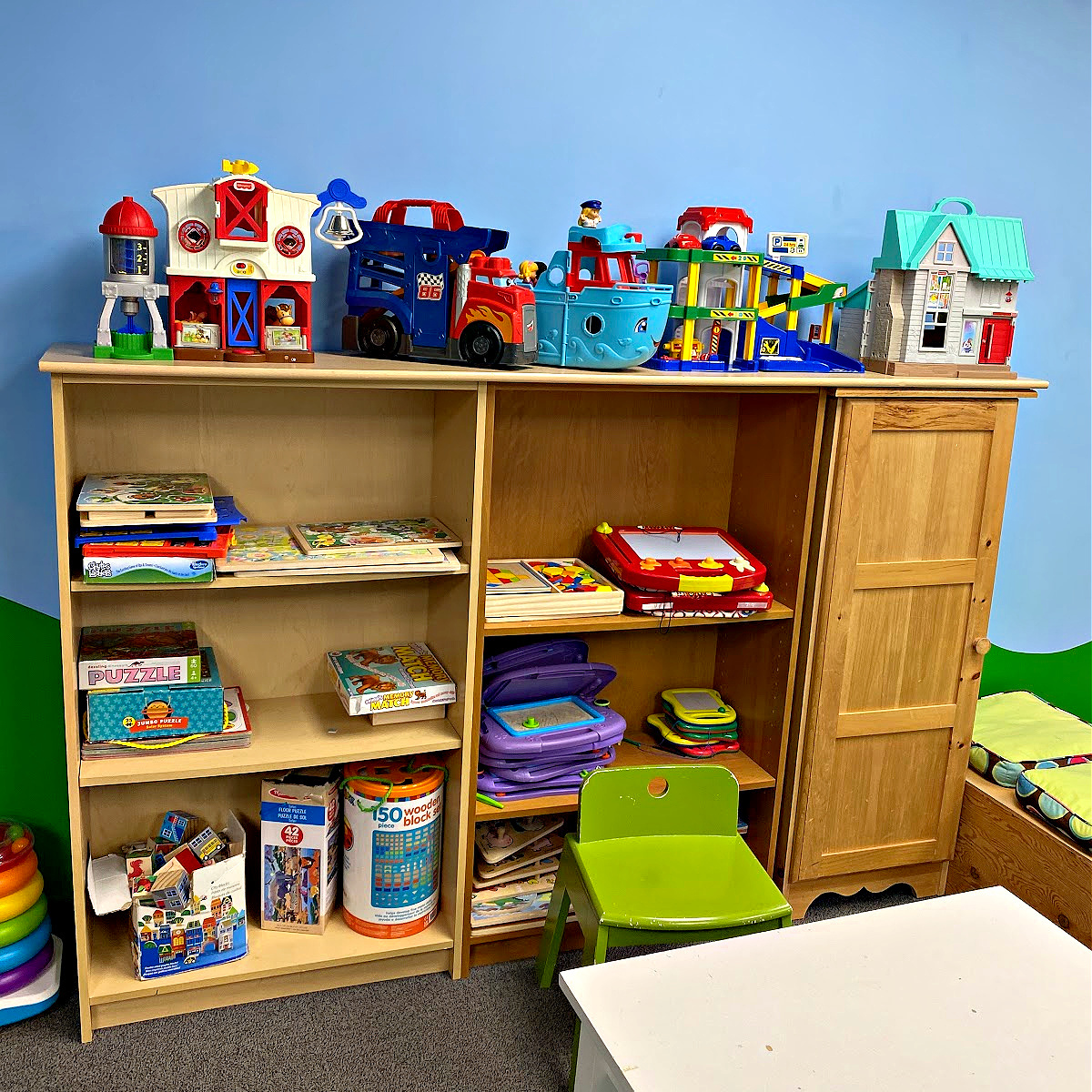 Wooden shelfing unit holding toys and puzzles for young children to play with.