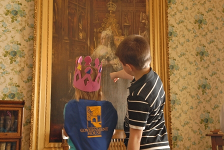 Two children point at large portrait of Queen Victoria in the Library of the museum