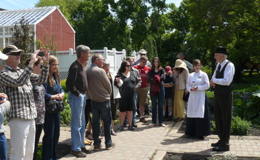 An actor dressed as George Watt giving a tour of the gardens of Government House SK