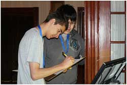 Two male students holding a clipboard and pencil, working on a scavenger hunt