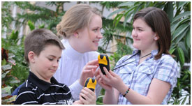 Vsitor Experience Host with two children holding GPS devices.