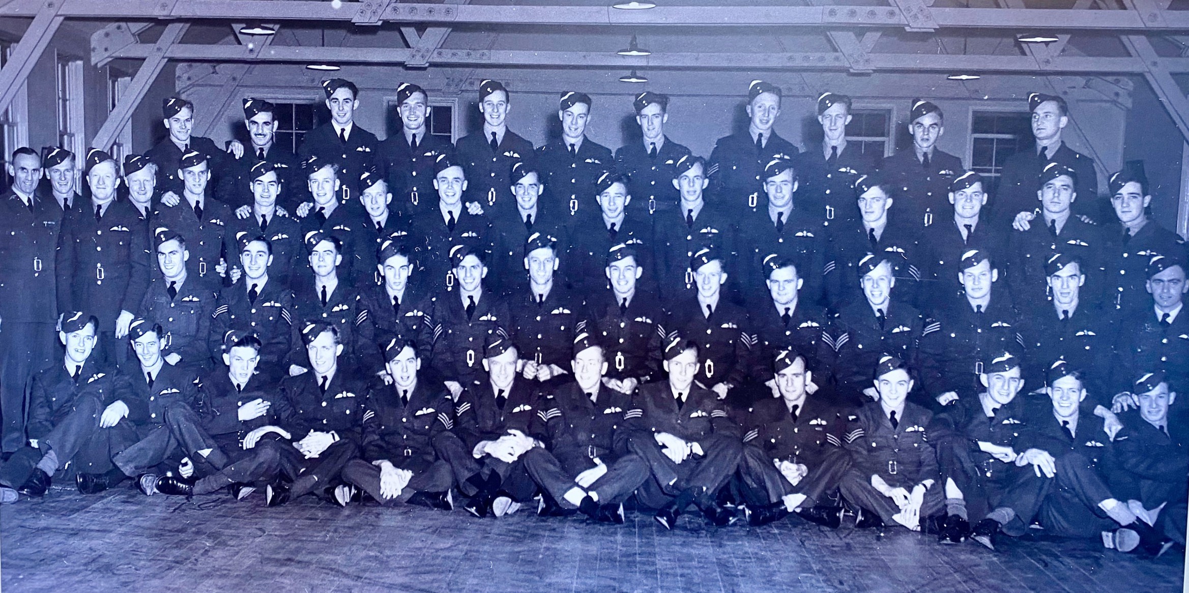 Military uniformed young men sitting and standing for a picture