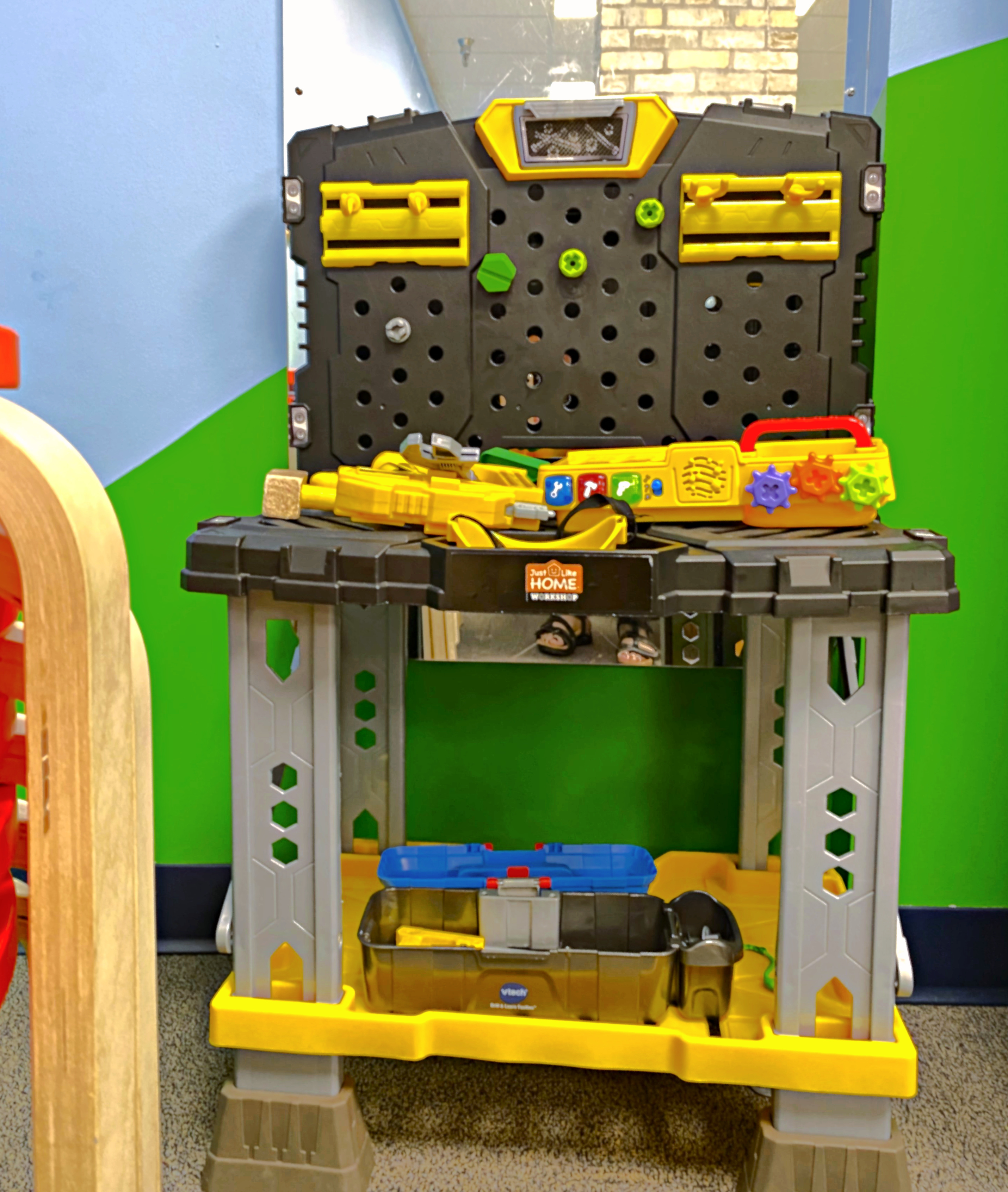 A work bench play station for children with plastic power tools, etc.